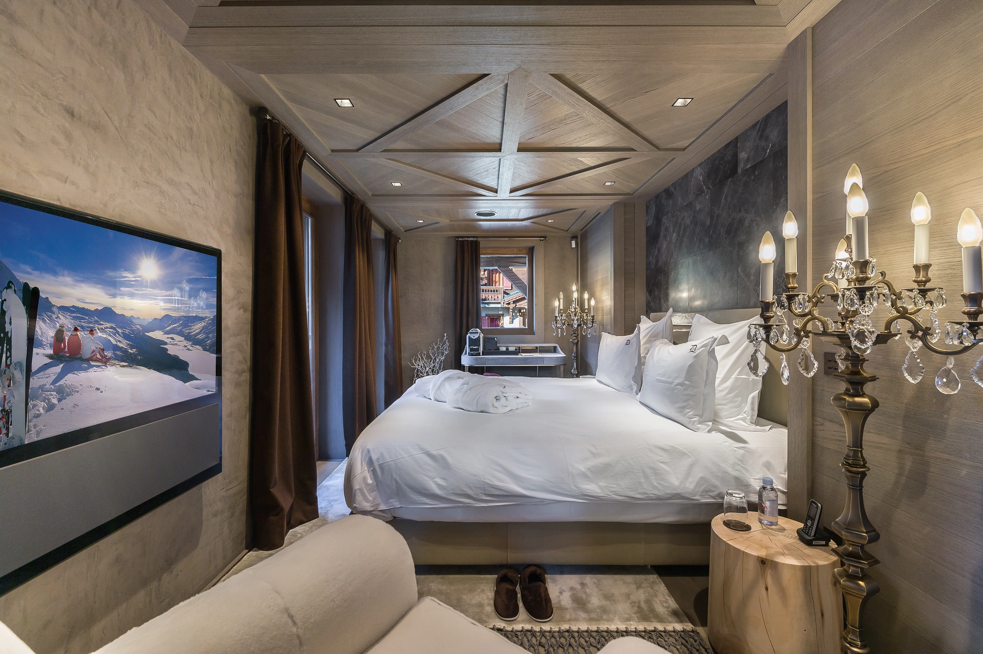 Master bedroom suite with chandelier and alpine artwork